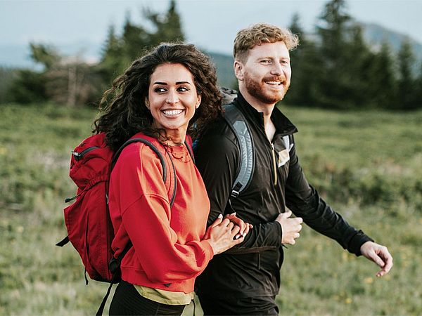 Junges Paar wandert durch eine schöne Berglandschaft.